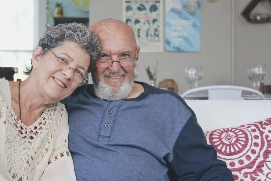 An older couple sitting together at home, smiling