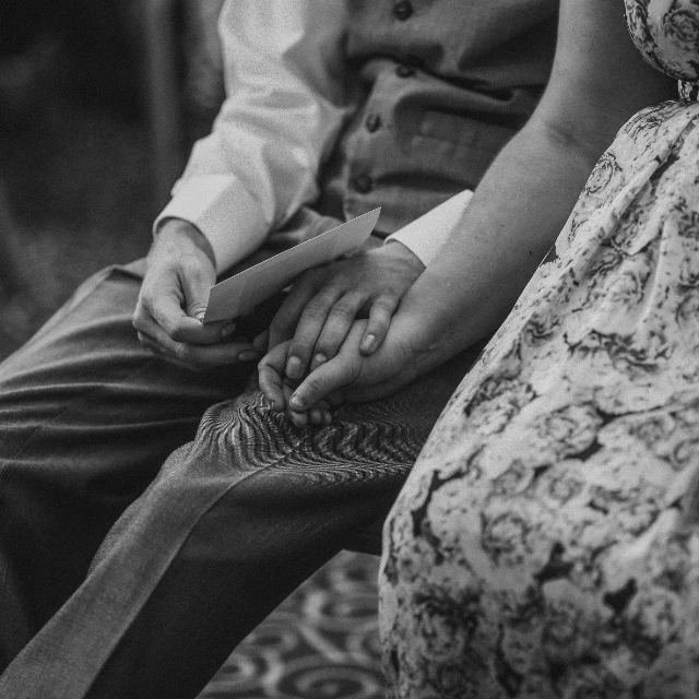 Close black and white photograph of an older person's hands resting in another's