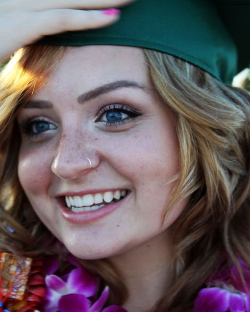 A graduate in a cap smiling on her graduation day