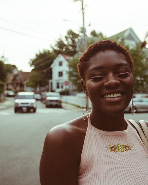 A woman smiling on a residential street in warm evening light