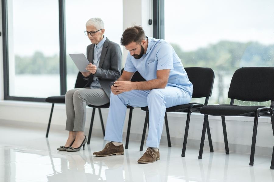 Two people sitting and talking in a bright waiting area