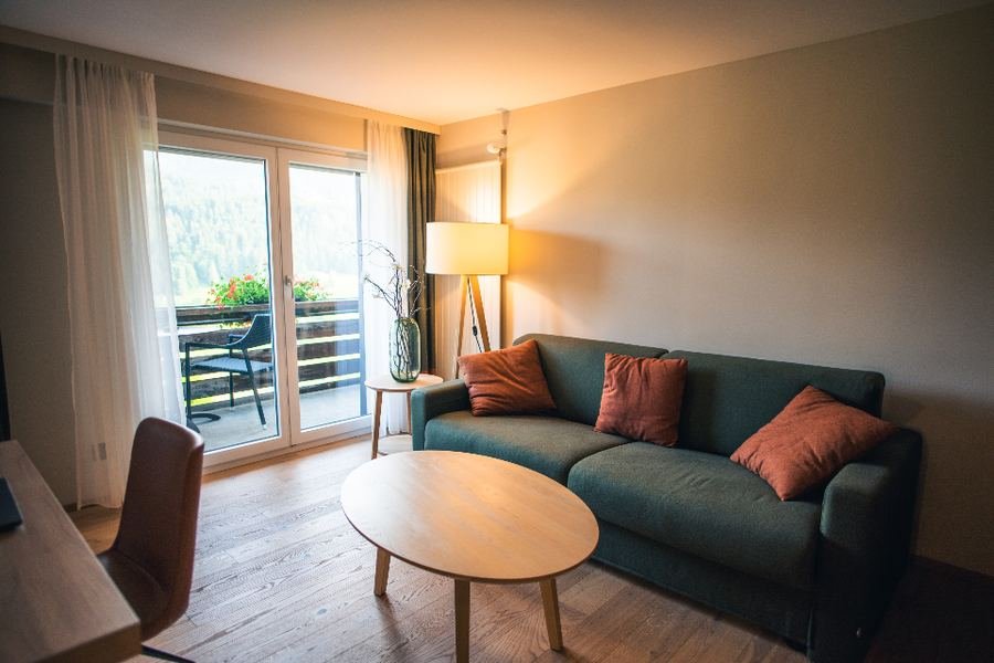 A warm, lamplit living room with a sofa and low table