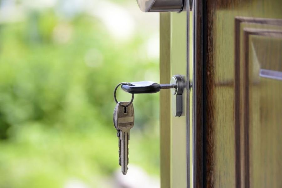 A set of keys hanging in the lock of a front door