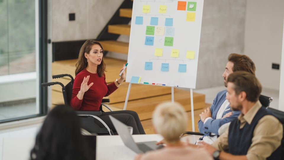An instructor presenting to a small group of adults seated around a table